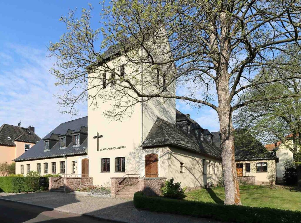 Die Heilandskirche im halleschen Stadtteil Frohe Zukunft, erbaut 1937–38 nach Plänen von Architekt Winfried Wendland. Blick auf Turm, Kirchenschiff und das angrenzende Gemeindehaus.